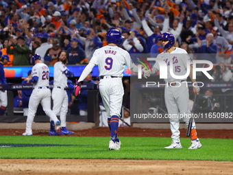 Brandon Nimmo #9 of the New York Mets is congratulated by teammate Tyrone Taylor #15 during the sixth inning in Game 3 of a baseball NL Divi...