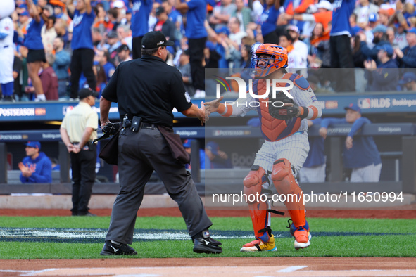 New York Mets catcher Francisco Alvarez #4 shakes hands with home plate umpire Doug Eddings during the first inning in Game 3 of a baseball...