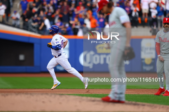 Pete Alonso #20 of the New York Mets rounds the bases after homering as Philadelphia Phillies starting pitcher Aaron Nola #27 stands on the...