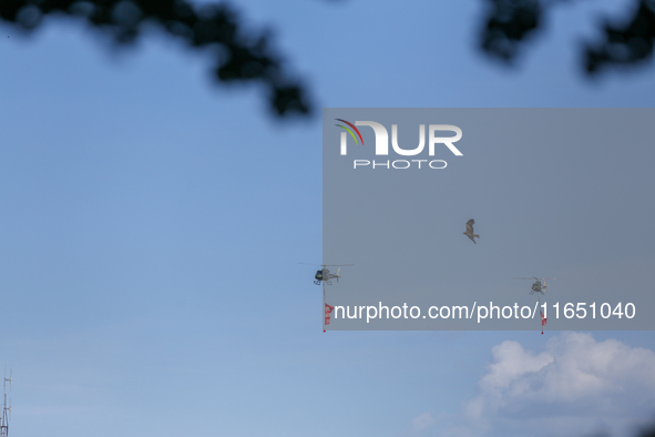 An eagle takes flight as a Nepal Army helicopter hoists the banner with wishes of Phulpati during the grand rehearsal in Nepal on October 8,...