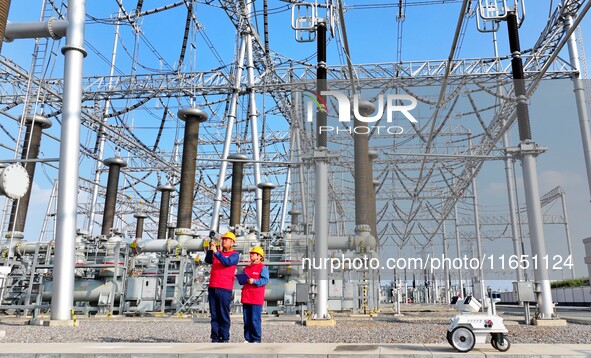 An intelligent robot and operation and maintenance personnel carry out a special inspection of the main equipment in the 500 kilovolt Tongle...