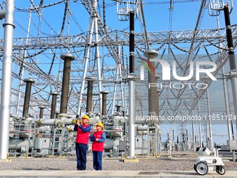 An intelligent robot and operation and maintenance personnel carry out a special inspection of the main equipment in the 500 kilovolt Tongle...