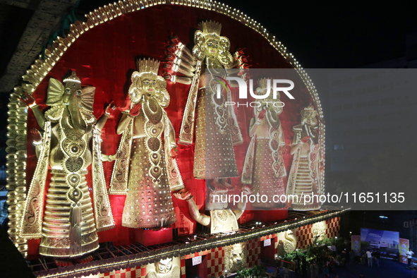 People gather at this 100-foot Hindu goddess Durga puja pandal, a temporary structure set up during the Durga Puja festival, near Kolkata, I...