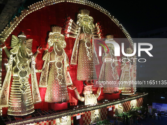 People gather at this 100-foot Hindu goddess Durga puja pandal, a temporary structure set up during the Durga Puja festival, near Kolkata, I...