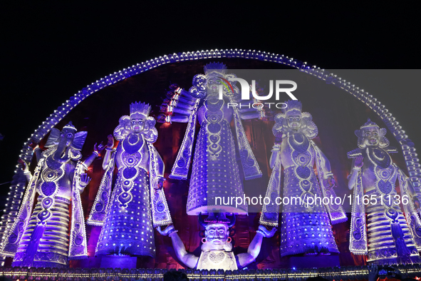 People gather at this 100-foot Hindu goddess Durga puja pandal, a temporary structure set up during the Durga Puja festival, near Kolkata, I...