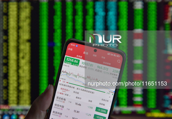 The day's stock index closing point displays on the mobile phone of a citizen in Fuyang, China, on October 9, 2024. 