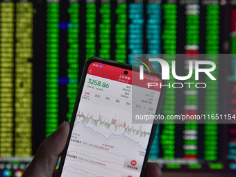 The day's stock index closing point displays on the mobile phone of a citizen in Fuyang, China, on October 9, 2024. (