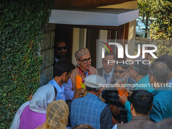 Jammu and Kashmir National Conference (JKNC) party leader Omar Abdullah (C) is greeted by supporters with garlands at his residence in Srina...