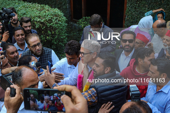 Jammu and Kashmir National Conference (JKNC) party leader Omar Abdullah (C) is greeted by supporters with garlands at his residence in Srina...