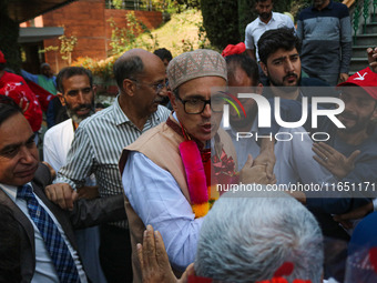 Jammu and Kashmir National Conference (JKNC) party leader Omar Abdullah (C) is greeted by supporters with garlands at his residence in Srina...