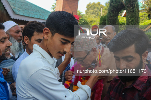 Jammu and Kashmir National Conference (JKNC) party leader Omar Abdullah (C) is greeted by supporters with garlands at his residence in Srina...