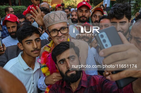 Supporters of the Jammu and Kashmir National Conference (JKNC) party take a selfie with party leader Omar Abdullah at his residence in Srina...