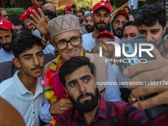 Supporters of the Jammu and Kashmir National Conference (JKNC) party take a selfie with party leader Omar Abdullah at his residence in Srina...