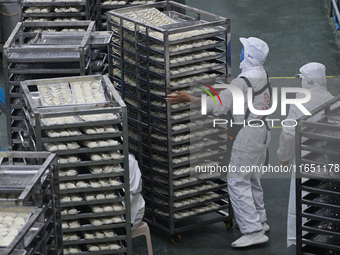 Workers make handmade dumplings in a workshop at a food factory in Suqian, China, on October 9, 2024. (