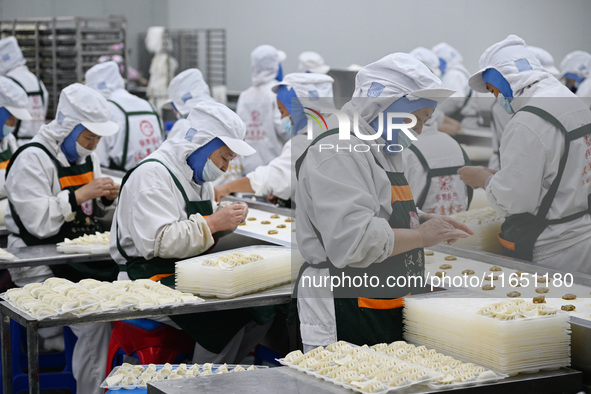 Workers make handmade dumplings in a workshop at a food factory in Suqian, China, on October 9, 2024. 