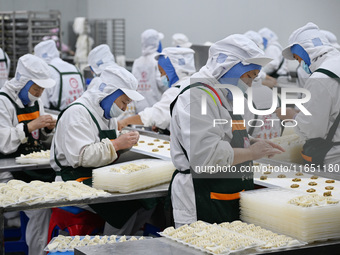 Workers make handmade dumplings in a workshop at a food factory in Suqian, China, on October 9, 2024. (