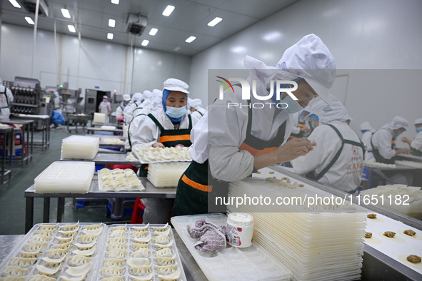 Workers make handmade dumplings in a workshop at a food factory in Suqian, China, on October 9, 2024. 