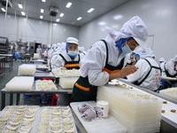 Workers make handmade dumplings in a workshop at a food factory in Suqian, China, on October 9, 2024. (