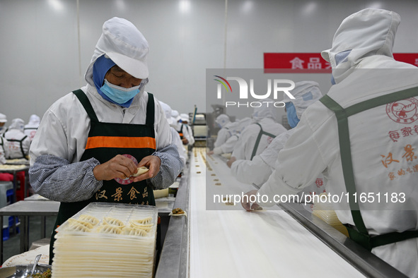 Workers make handmade dumplings in a workshop at a food factory in Suqian, China, on October 9, 2024. 