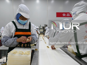 Workers make handmade dumplings in a workshop at a food factory in Suqian, China, on October 9, 2024. (