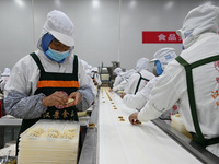 Workers make handmade dumplings in a workshop at a food factory in Suqian, China, on October 9, 2024. (