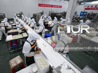 Workers make handmade dumplings in a workshop at a food factory in Suqian, China, on October 9, 2024. (