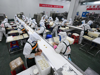 Workers make handmade dumplings in a workshop at a food factory in Suqian, China, on October 9, 2024. (