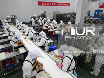 Workers make handmade dumplings in a workshop at a food factory in Suqian, China, on October 9, 2024. (