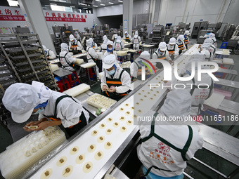 Workers make handmade dumplings in a workshop at a food factory in Suqian, China, on October 9, 2024. (