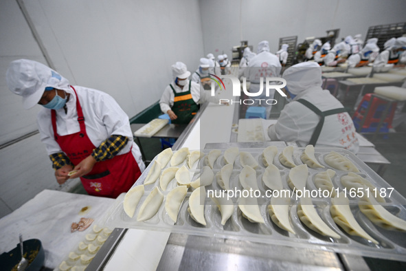 Workers make handmade dumplings in a workshop at a food factory in Suqian, China, on October 9, 2024. 