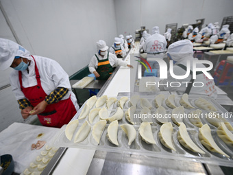 Workers make handmade dumplings in a workshop at a food factory in Suqian, China, on October 9, 2024. (