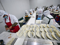 Workers make handmade dumplings in a workshop at a food factory in Suqian, China, on October 9, 2024. (