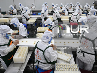 Workers make handmade dumplings in a workshop at a food factory in Suqian, China, on October 9, 2024. (