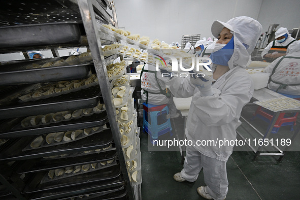 Workers make handmade dumplings in a workshop at a food factory in Suqian, China, on October 9, 2024. 