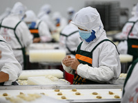 Workers make handmade dumplings in a workshop at a food factory in Suqian, China, on October 9, 2024. (