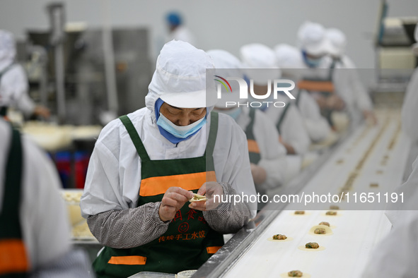 Workers make handmade dumplings in a workshop at a food factory in Suqian, China, on October 9, 2024. 