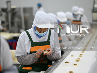 Workers make handmade dumplings in a workshop at a food factory in Suqian, China, on October 9, 2024. (