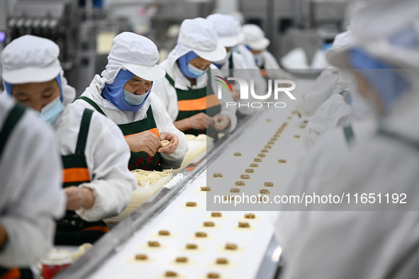 Workers make handmade dumplings in a workshop at a food factory in Suqian, China, on October 9, 2024. 