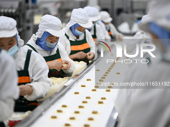 Workers make handmade dumplings in a workshop at a food factory in Suqian, China, on October 9, 2024. (