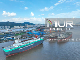 Workers at a ship maintenance company repair a ship in Zhoushan, China, on October 9, 2024. (