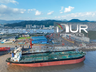 Workers at a ship maintenance company repair a ship in Zhoushan, China, on October 9, 2024. (