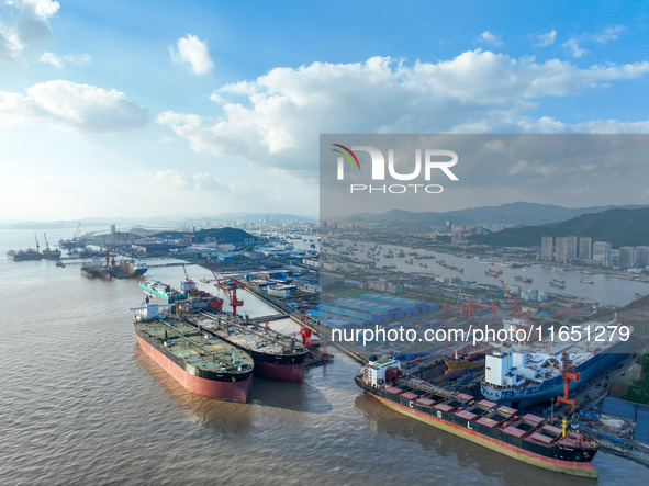 Workers at a ship maintenance company repair a ship in Zhoushan, China, on October 9, 2024. 