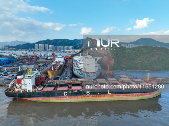 Workers at a ship maintenance company repair a ship in Zhoushan, China, on October 9, 2024. 