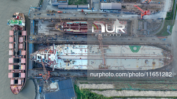 Workers at a ship maintenance company repair a ship in Zhoushan, China, on October 9, 2024. 