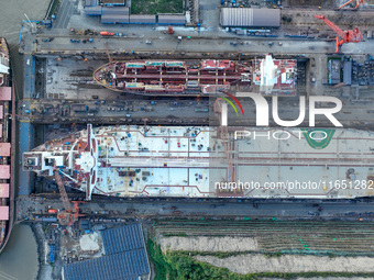 Workers at a ship maintenance company repair a ship in Zhoushan, China, on October 9, 2024. (