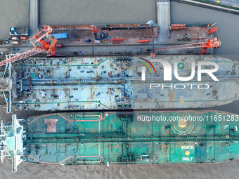 Workers at a ship maintenance company repair a ship in Zhoushan, China, on October 9, 2024. (