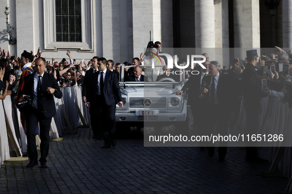 Pope Francis waves to the crowd from the popemobile as he arrives for the weekly general audience at St. Peter's Square in The Vatican on Oc...