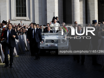 Pope Francis waves to the crowd from the popemobile as he arrives for the weekly general audience at St. Peter's Square in The Vatican on Oc...