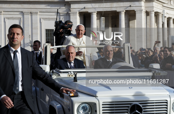 Pope Francis waves to the crowd from the popemobile as he arrives for the weekly general audience at St. Peter's Square in The Vatican on Oc...