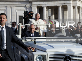 Pope Francis waves to the crowd from the popemobile as he arrives for the weekly general audience at St. Peter's Square in The Vatican on Oc...